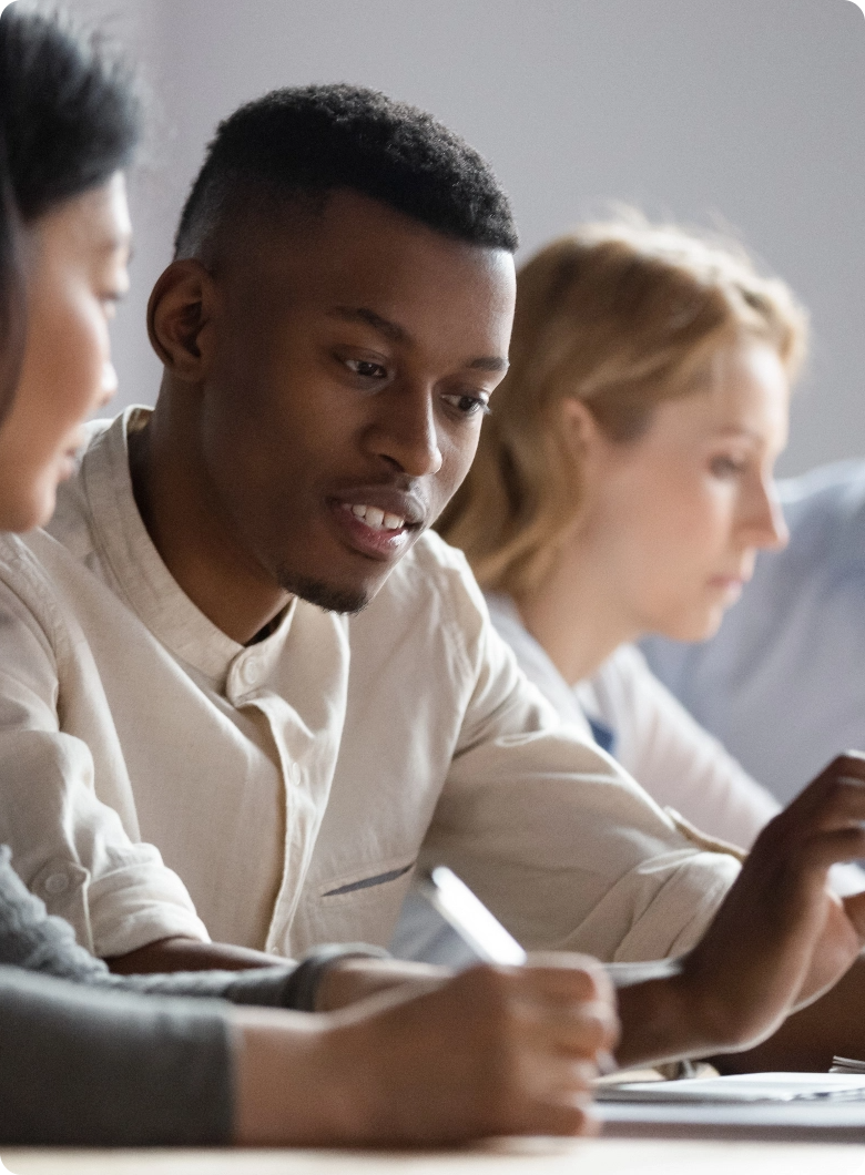 People sitting in a row at a desk having a conversation